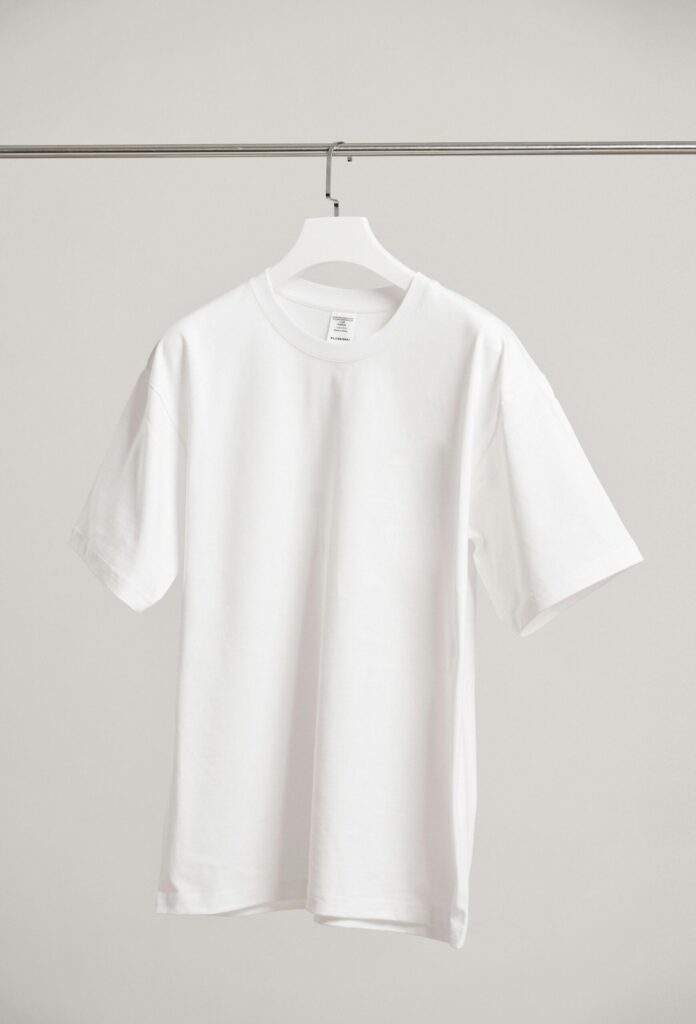Simple white t-shirt hanging in a modern Shanghai boutique, emphasizing fashion minimalism.